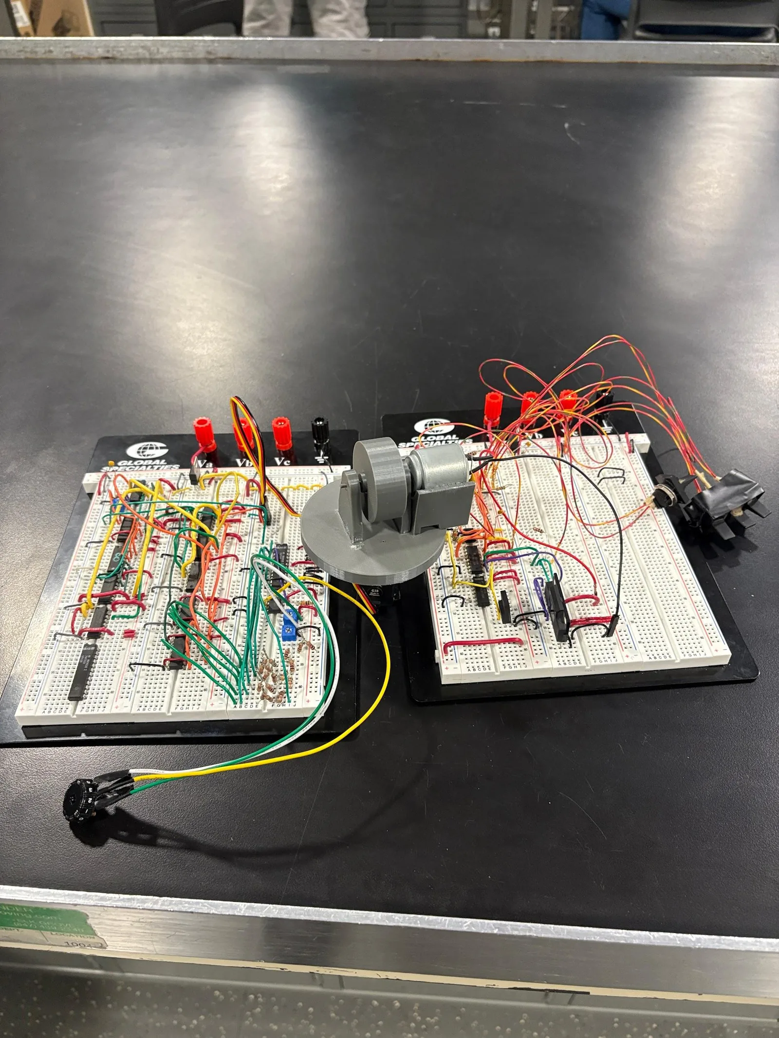 Complete assembled analog swerve module with drive motor, steering servo, and both control breadboards