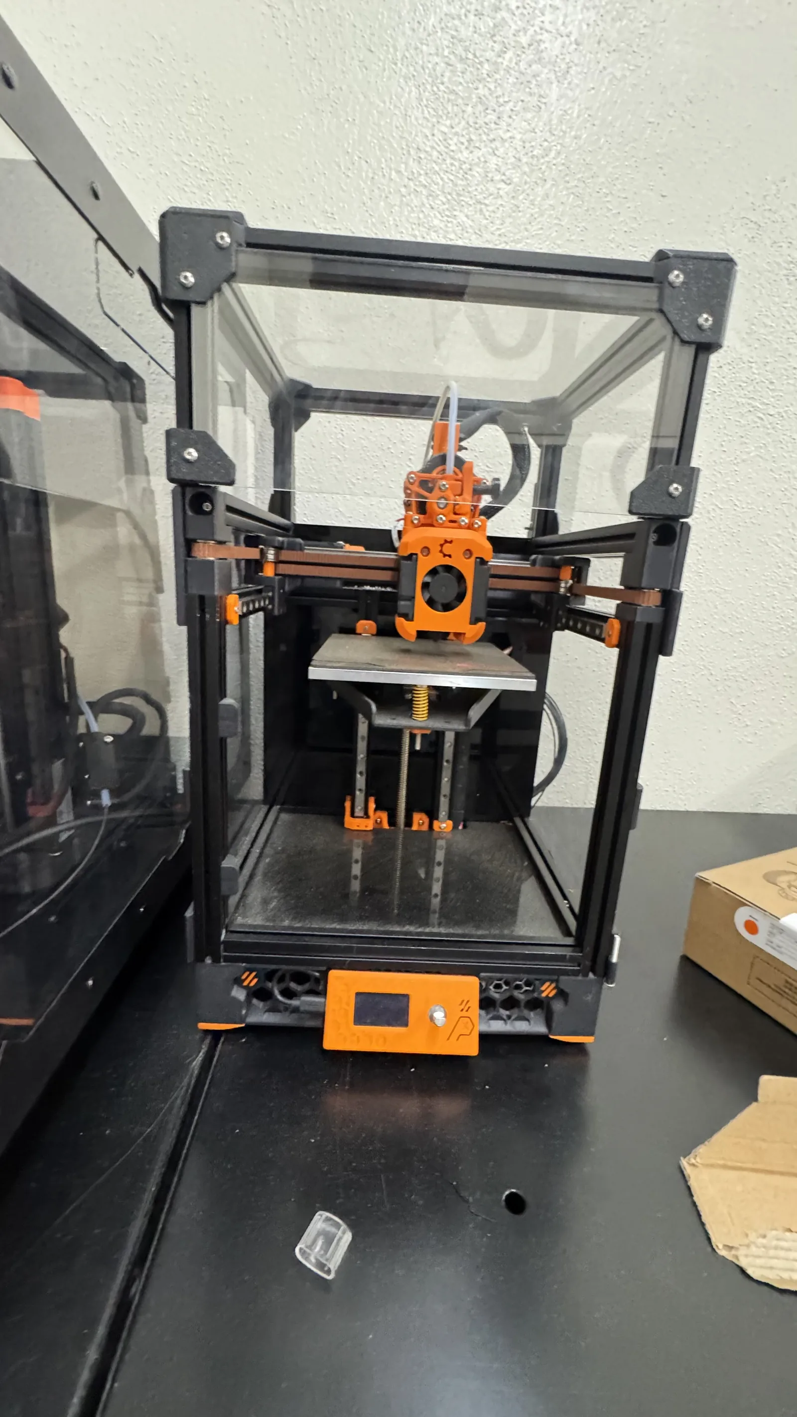 Completed orange and black Voron V0 printer built for the robotics team